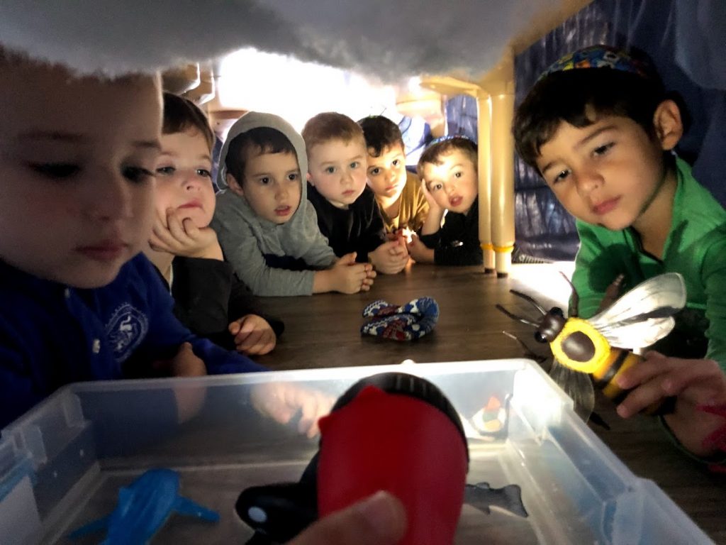 Preschool children exploring a hands-on discovery activity together.