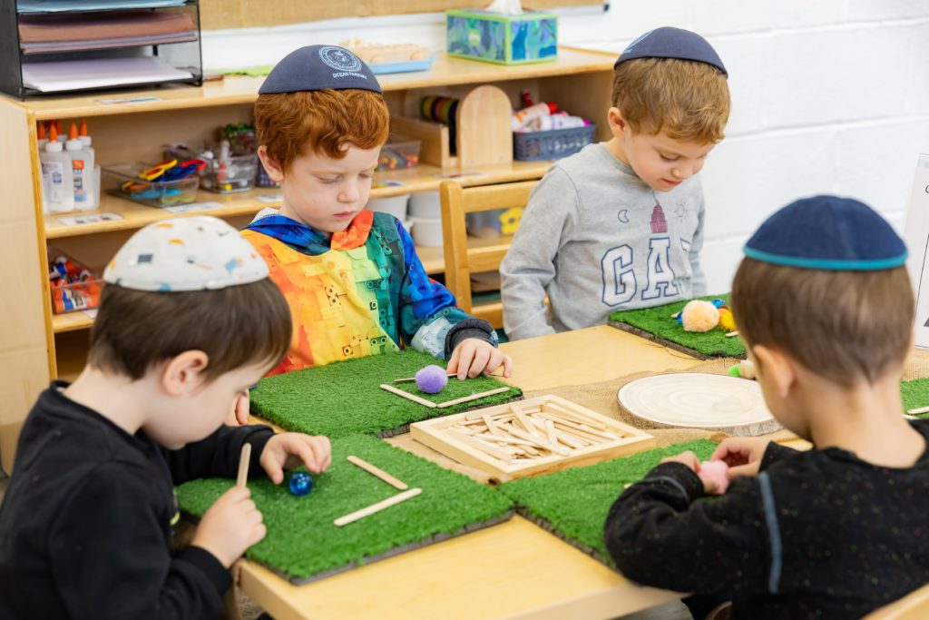 Young Talmidim working together at a hands-on Alef Beis activity.